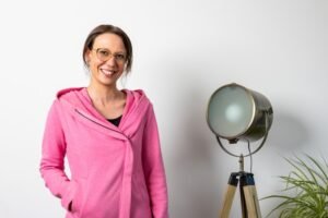 FEMME EN VESTE ROSE À COTÉ D'UNE LAMPE