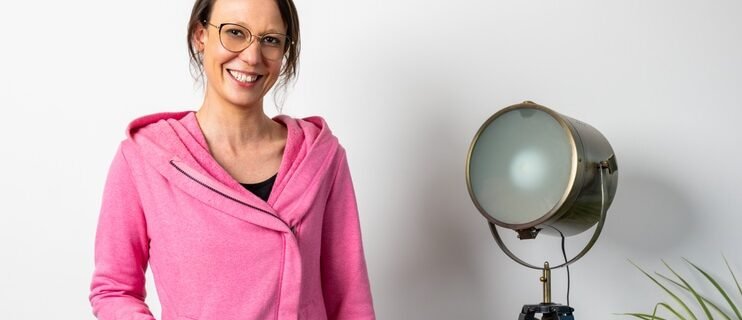 FEMME EN VESTE ROSE À COTÉ D'UNE LAMPE