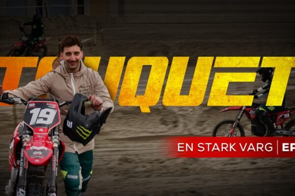 Pilote de motocross avec sa moto rouge.